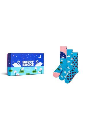 Geschenkschachtel neben drei bunten Socken mit Schwänen, Seerosen, Pünktchen- und Nachthimmelmustern auf einem weißen Hintergrund.