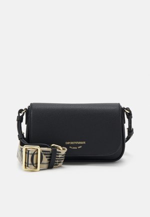 Black leather crossbody bag with a textured surface. Features a gold logo and a patterned fabric strap with a metal buckle.