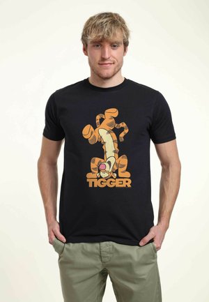 Černé bavlněné tričko s velkým oranžovým a žlutým grafickým motivem Tiggera a textem "TIGGER" pod ním. Krátké rukávy a kulatý výstřih.