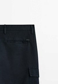 Czarne spodnie cargo z zapięciem na guzik, szlufkami na pasek i tylną kieszenią. Wykonane z trwałego materiału o gładkiej fakturze.