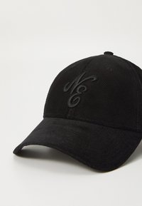 Black corduroy cap featuring an embroidered logo in matching black. The design includes a curved brim and textured fabric.