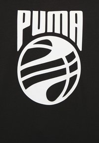 Texte stylisé "PUMA" en blanc au-dessus d'un graphique abstrait de basket-ball blanc sur un fond noir, ressemblant à un logo ou un design graphique.