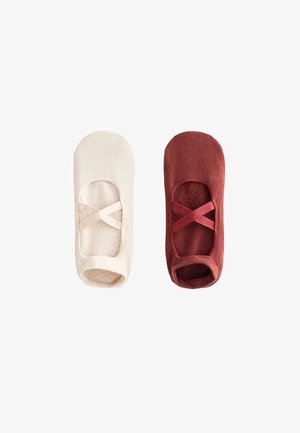 Dva čarapa bez vidljivog ruba s ukriženim elastičnim trakama, jedna bež i jedna tamnocrvena, prikazane jedna pored druge na bijeloj pozadini.