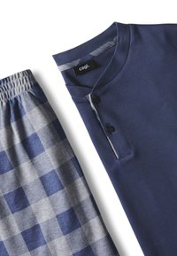 Top in cotone blu navy con colletto a V e dettagli a bottone, abbinato a pantaloni paia in grisaglia blu e grigia con vita elasticizzata.