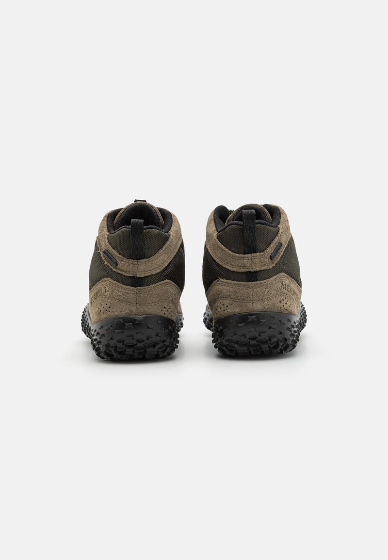 Bruine en zwarte schoenen met een bovenwerk van suède en mesh, laag enkelontwerp, en een rubberen zool met een gestructureerd patroon.