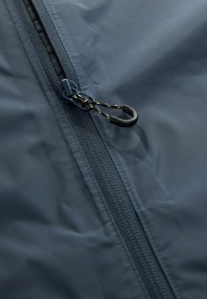 Marine waterdichte jas met een rits aan de voorkant, voorzien van een gestructureerde stof en een zwarte trekhaak met een kleine haak voor aanpassing.