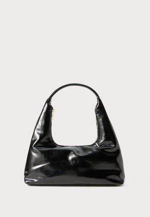 Black patent leather handbag with a semi-circular handle, trapezoidal shape, smooth texture, and a single zip closure detail.