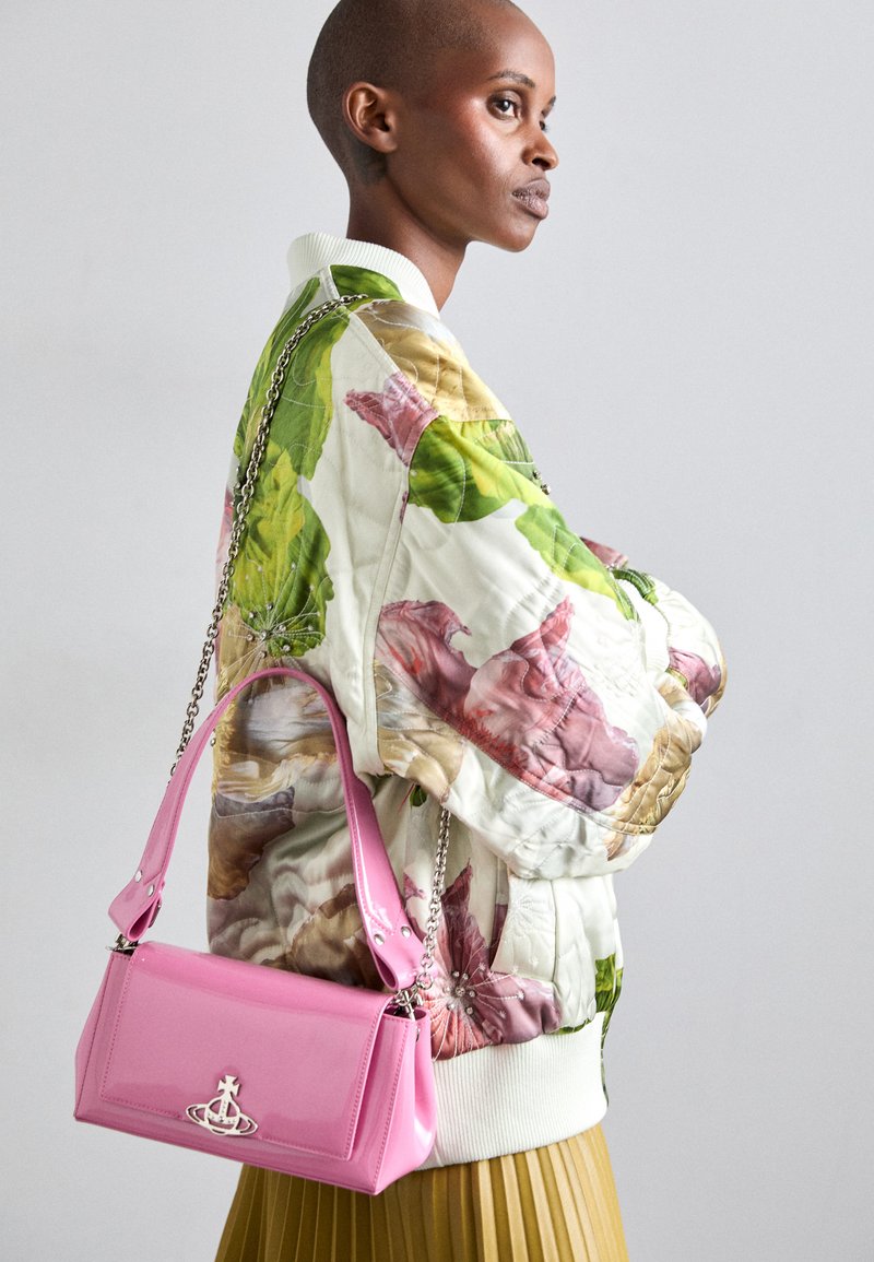 Quiltana bomber jakna s cvetnim vzorcem v zeleni, roza in bež barvi; v kombinaciji z sijočo roza torbico z verižnim ročajem in logotipom.