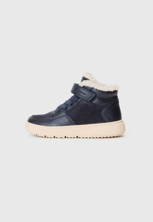 Botas de tornozelo azul-marinho feitas em couro e camurça, com um forro de pele macia, atacadores na frente e uma faixa de Velcro, e uma sola texturizada.