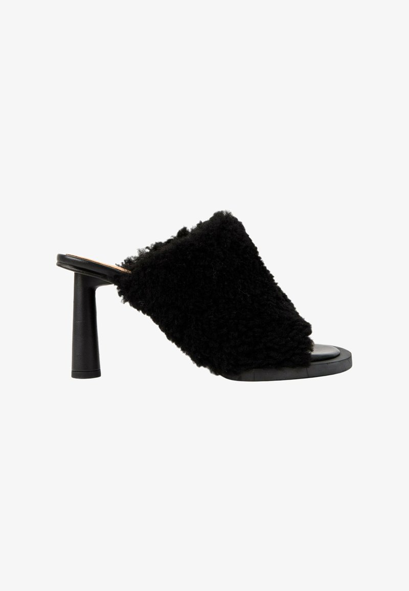 Mule noire à bout ouvert avec talon cylindrique haut et tige texturée et duveteuse couvrant l'avant du pied.