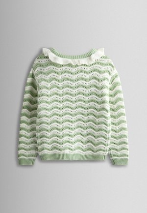 Gaiši zaļš adīts džemperis ar viļņotu rakstu mainīgās baltās joslās. Tam ir volānu balts apkakle un ribota apdare piedurknēm un apakšmalai.