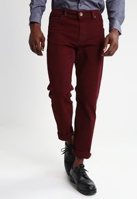 Pantaloni slim-fit bordeaux realizzati in cotone resistente, con un classico design a cinque tasche, orli arrotolati e chiusura con bottone.