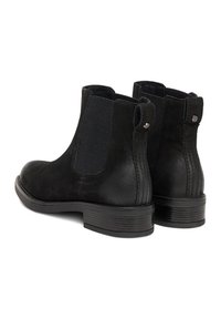 Botines de cuero negro con paneles laterales elásticos, acabado texturizado y pequeños detalles metálicos en el tacón. Suela plana con leve elevación.