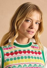Ärmelloser Strickpullover mit einem mehrfarbigen Fruchtmuster, das rote Erdbeeren, rosa Beeren und grüne Blätter zeigt; grüner gerippter Halsausschnitt und Ränder.