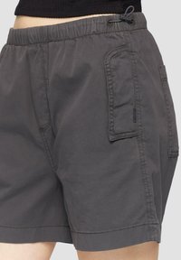 Grijze shorts met een elastische tailleband, verstelbare koord en zijzak. De stof lijkt lichtgewicht met een gladde textuur.