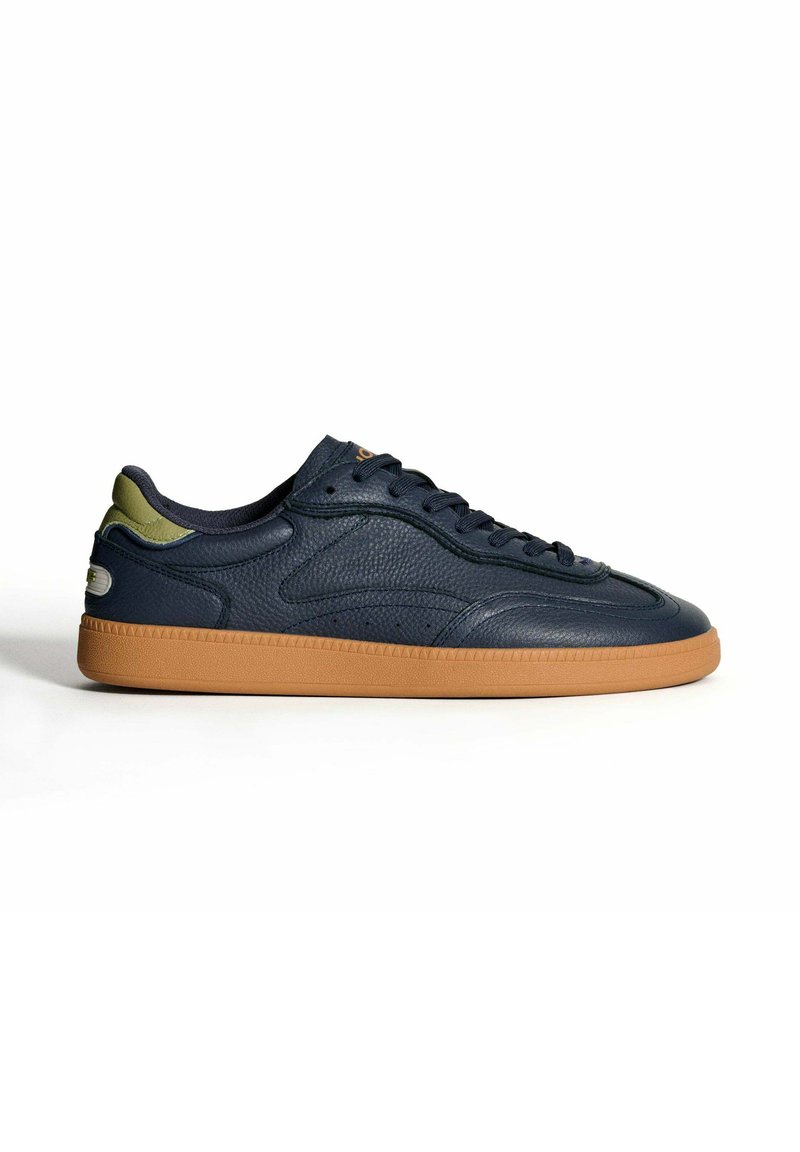 Zapatillas de cuero azul marino con un acabado texturizado, que cuentan con una suela de goma de color marrón y acentos en verde oliva en la zona del talón y la lengua.