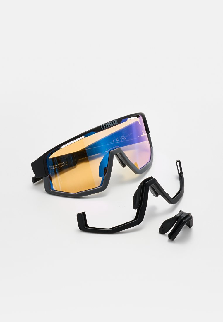 Sportsonnenbrille mit lila-orange spiegelnden Gläsern, schwarzem Rahmen und zwei separaten verstellbaren Nasen- und Ohrstücken aus schwarzem Kunststoff auf weißem Hintergrund.