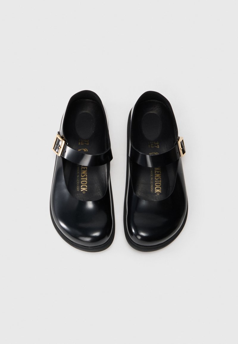 Zapatos de cuero negros con puntera redonda, una correa y hebilla dorada. Superficie lisa con plantilla acolchada y suela resistente. Talla 37.