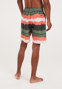 Zwemshorts gemaakt van lichtgewicht stof met een tie-dye patroon in oranje, groen en witte strepen, voorzien van een elastische tailleband en een achterzak.