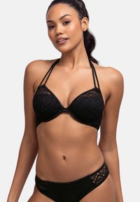 Svart spetsbralette med texturerade mönster och justerbara axelband, tillsammans med en matchande bikiniunderdel med spetsdetaljer.