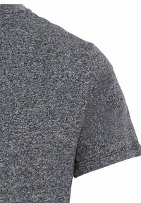 Grijs T-shirt met korte mouwen, gemaakt van textuurstof, met een ronde halslijn en een casual pasvorm, voorzien van zichtbare stiksels op de mouwen.