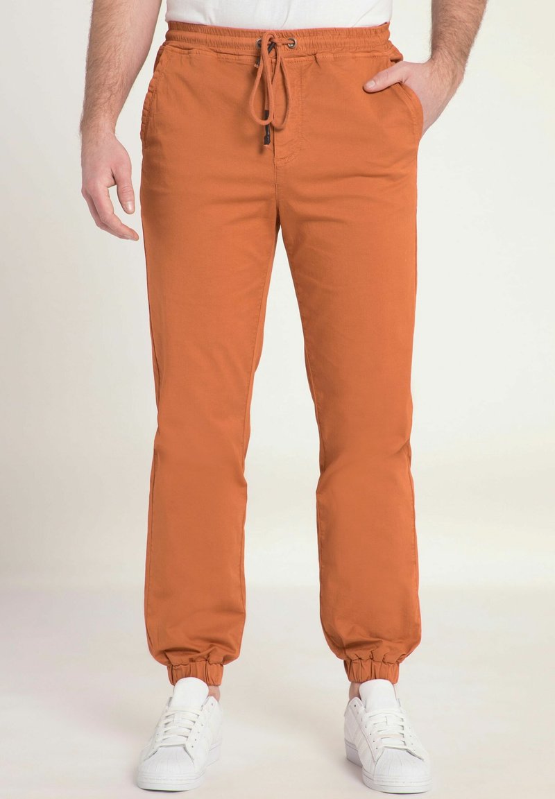 Orange joggerbyxor med elastiska muddar och dragsko i midjan, med sidofickor och ett mjukt, lätt tyg.