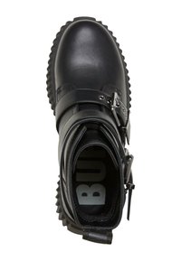 Botín de cuero negro hasta el tobillo con puntera redondeada, detalle de correa, acentos metálicos y suela texturizada. El interior muestra una plantilla con la marca.