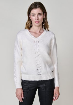 Pull à col en V, manches longues, en matière blanche douce ; il présente un motif en dentelle de diamant sur le devant et des bords côtelés aux manches et à l'ourlet.