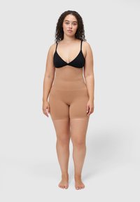 Gorsetowa bielizna modelująca w kolorze nude, z wysokim stanem i długością do połowy uda. Gładki materiał o elastycznej strukturze, bez widocznych szwów.