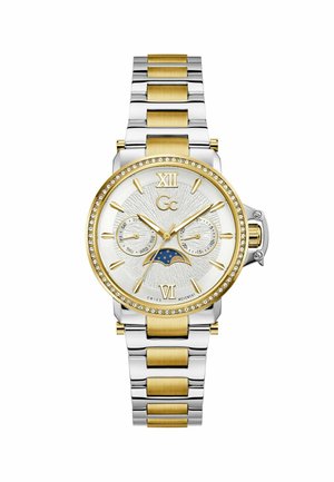 Ceas de mână bicolor din aur și argint cu bezel împodobit cu cristale, subcifre pentru zi și dată, și indicator al fazelor lunii pe un cadran texturat alb.