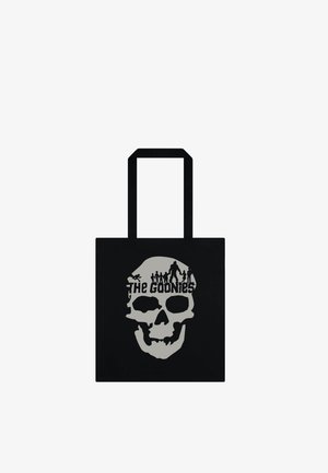 Borsa tote nera con disegno di teschio grigio, silhouette di persone sopra e testo "The Goonies" all'interno del teschio.