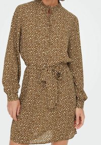 Vestito marrone a maniche lunghe con un motivo a pois, dotato di colletto rialzato, chiusura con bottoni e una cintura in tessuto in vita per un look aderente.
