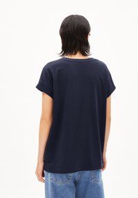 Navyblauwe katoenen t-shirt met een relaxte pasvorm, opgerolde korte mouwen en een ronde hals, met een schone, minimalistische uitstraling.