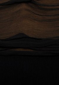 Kerami bersusun yang menampilkan tekstur bergelombang dalam nuansa coklat gelap dan hitam, dengan sedikit kilau dan variasi halus yang menonjolkan kedalaman bahan.
