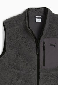 Grauer Fleece-Westen mit Reißverschluss vorne und einer kontrastierenden grauen Brusttasche mit schwarzen Akzenten und einem Puma-Logo. Weiche Textur.