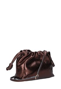 Metalen bronzen trekkoord tas met een cinched top, zachte textuur, slanke schouderband en een klein gouden hardware detail.