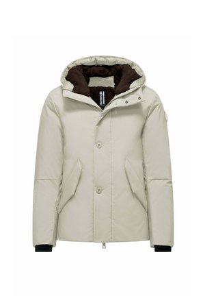 Licht beige pufferjack met een capuchon, voorzien van een bruine fleece voering, zijzakken en zwarte geribbelde manchetten. Voorzien van een knoop- en ritsluiting aan de voorkant.