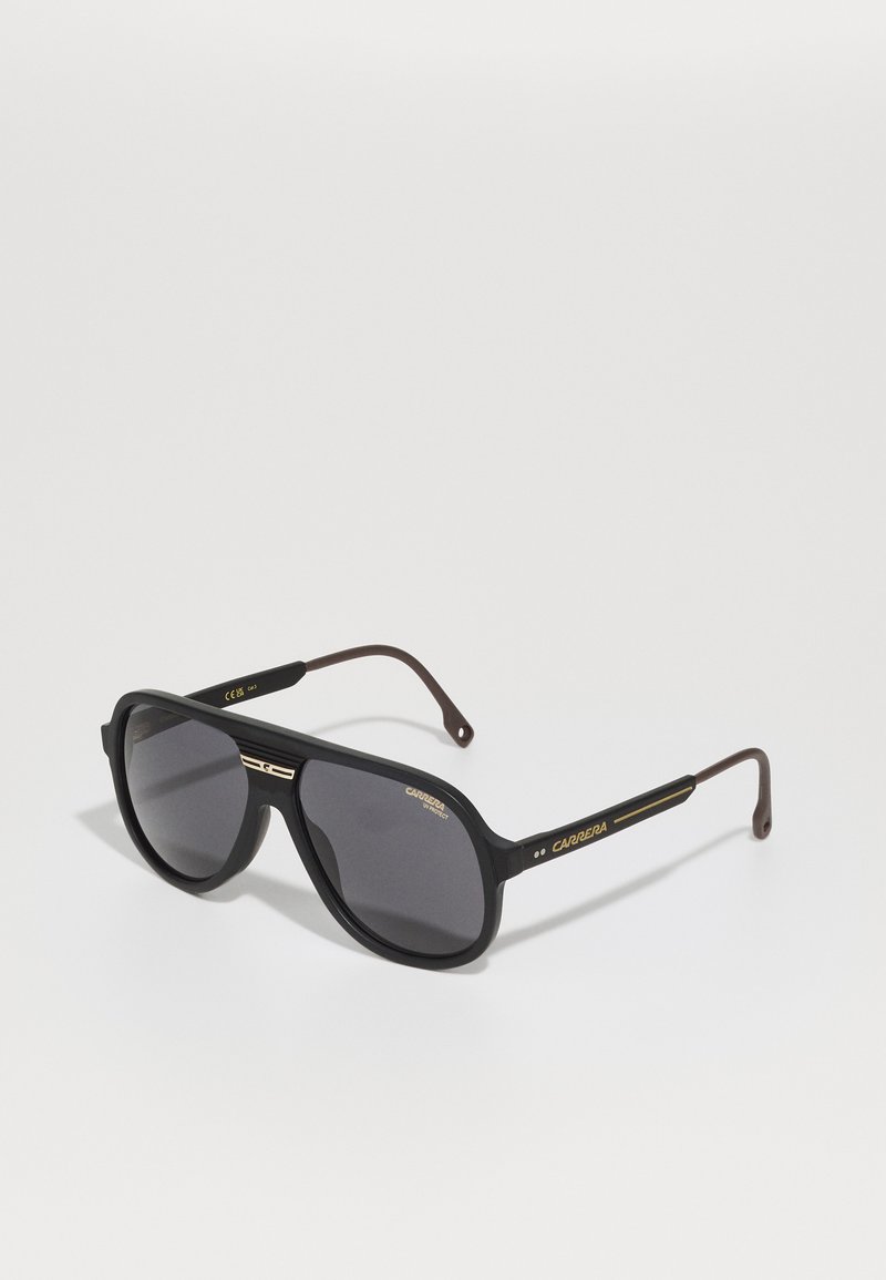 Ochelari de soare supradimensionați, de culoare neagră, cu lentile gri, având un finisaj mat, accente aurii pe brațe și un design elegant, geometric.