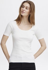 Top alb cu dungi, cu mânecă scurtă și decolteu rotund, având o siluetă ajustată și o textură netedă. Design simplu și versatil.