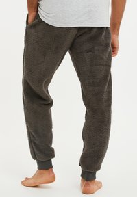 Fleece joggers in donkergrijs, met een zachte textuur, elastische boorden en zijzakken voor functionaliteit en comfort.