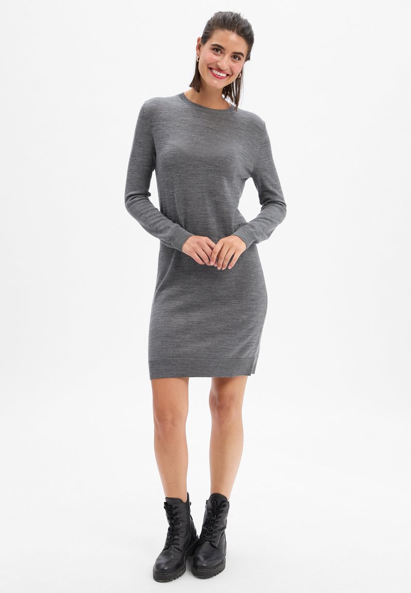 Robe bodycon à manches longues grise avec des poignets et un ourlet côtelés, en tissu tricoté texturé, complétée par des bottes noires à lacets.