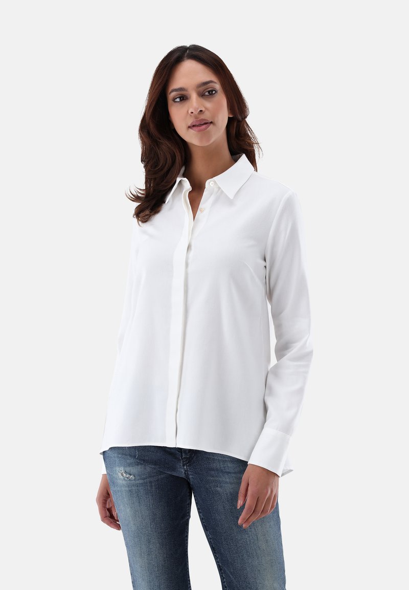 White button-up shirt in soft fabric, featuring a classic collar, long sleeves, and a relaxed fit, paired with blue distressed jeans.