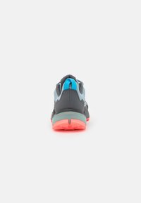 Zapatillas deportivas con un upper en gris y azul, malla texturizada suave, una entresuela verde acolchada y una suela exterior en coral brillante.