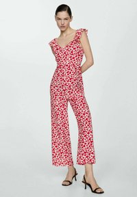 Červený květinový overal s přiléhavým živůtkem, volánkovými krátkými rukávy a širokými nohavicemi. Vyroben z lehkého materiálu, s jemným vzorem.