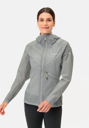 Giacca leggera da pioggia grigia con cappuccio, chiusura frontale con zip, polsini elasticizzati e tasche laterali. Presenta dettagli della zip in giallo.