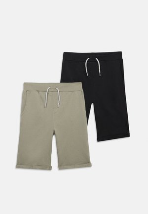 Két pár térdig érő, laza szabású rövidnadrág húzózsinóros derékrésszel, egyik bézs, a másik fekete, laposan fektetve fehér háttér előtt.