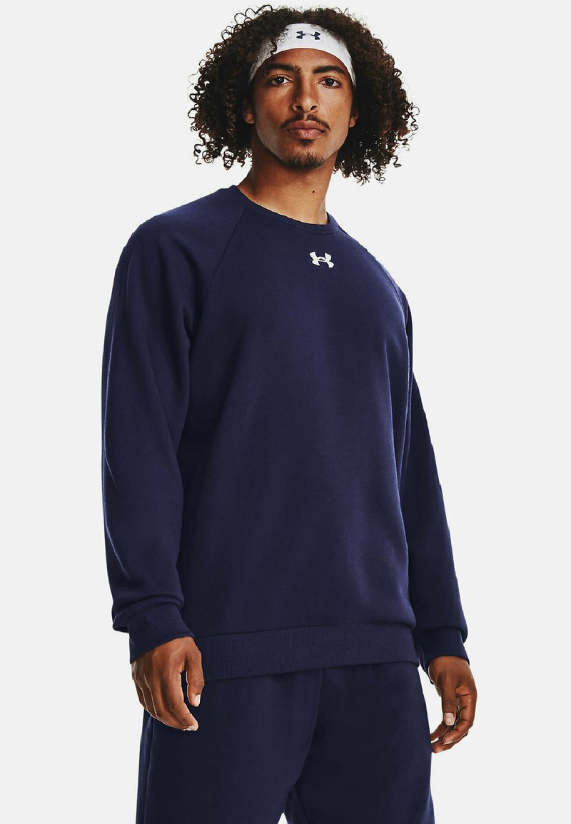 Sudadera de felpa de color azul marino con puños y dobladillo acanalados, con un logo blanco en el pecho. El diseño incluye un cuello redondo y mangas largas.