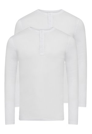 Hvid langærmet skjorte lavet af bomuld. Har en rund hals og en knaplukning foran. Glat tekstur og enkelt design.