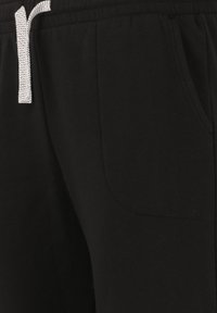 Zwarte katoenen sweatpants met een tailleband met trekkoord, voorzien van een voorzak en een gladde textuur.