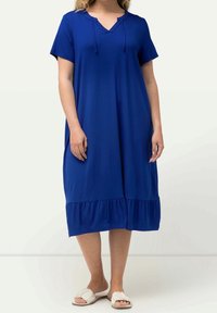 Blauwe jurk met korte mouwen, een V-hals, trekkoorddetails en een gerimpelde zoom. Gemaakt van een zachte stof, heeft een A-lijn vorm.